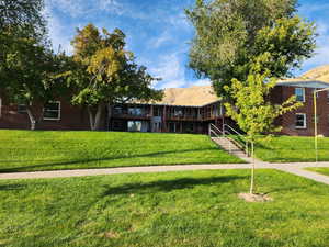 View of property's community featuring a mountain view, a yard, and stairway