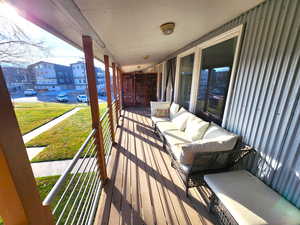 Wooden deck with an outdoor living space and a lawn