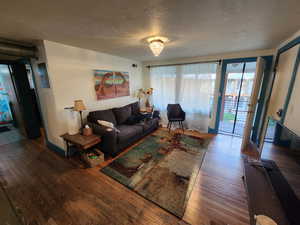 Living room with a textured ceiling and wood finished floors