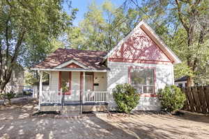 View of front of house with covered porch and roof with shingles