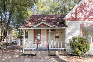 View of front facade with a porch and roof with shingles