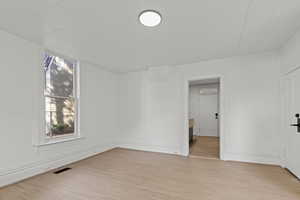 Empty room with light wood-style flooring and baseboards