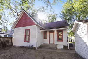 View of front of house with covered porch and roof with shingles