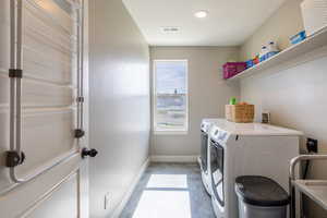 Laundry room featuring baseboards and washing machine and clothes dryer