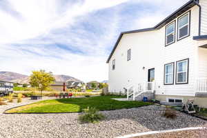 Back of house featuring a lawn and a mountain view