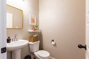 Half bathroom with toilet and baseboards