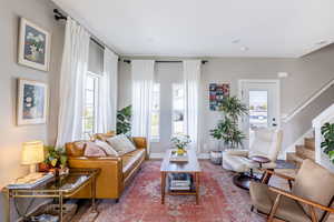 Living room featuring stairs and baseboards