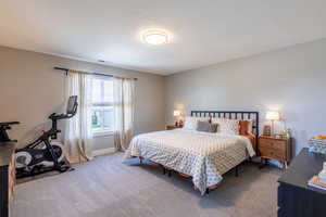 Bedroom with carpet floors and a textured ceiling