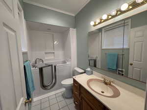 Bathroom with light tile patterned floors, a bath, vanity, and crown molding