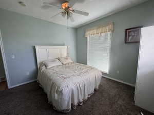 Bedroom featuring dark carpet and ceiling fan