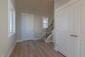 Foyer entrance featuring stairway, wood finished floors, and plenty of natural light