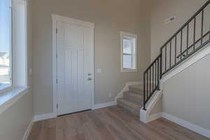 Foyer with stairs and wood finished floors