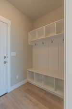 Mudroom featuring light wood finished floors and baseboards