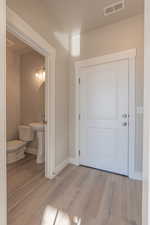 Hall with light wood finished floors and baseboards