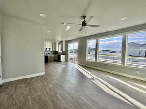 Unfurnished living room with recessed lighting, ceiling fan, dark wood-style floors, and a textured ceiling