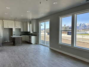 Kitchen with dark wood finished floors, recessed lighting, white cabinetry, a textured ceiling, and a kitchen island