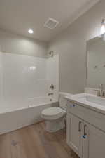 Bathroom featuring shower / bath combination, vanity, light wood-style flooring, and recessed lighting