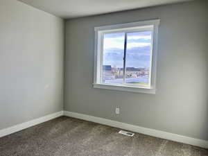 Spare room featuring baseboards and carpet