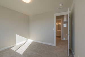 Carpeted spare room with baseboards