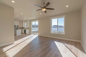 Unfurnished living room featuring recessed lighting, light wood finished floors, healthy amount of natural light, and ceiling fan