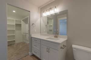 Full bathroom with vanity, dark wood-style floors, recessed lighting, and a spacious closet