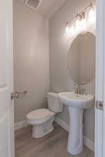 Half bath with baseboards and light wood-style floors
