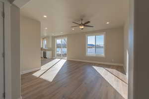 Unfurnished living room with light wood finished floors, a ceiling fan, and recessed lighting