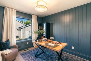 Home office featuring baseboards and wood walls