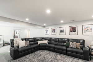 Carpeted living room with recessed lighting
