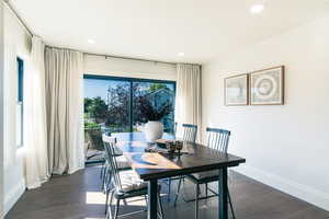 Dining area with dark wood-style flooring and recessed lighting