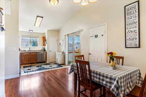 Dining room featuring dark wood finished floors and vaulted ceiling