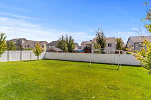 Fenced backyard featuring a residential view