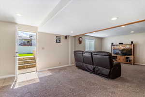 Living room featuring light colored carpet, recessed lighting, light tile patterned floors, and walkout.