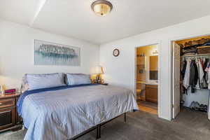 Carpeted bedroom with a walk in closet