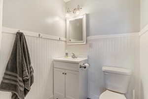 Bathroom with vanity and a wainscoted wall