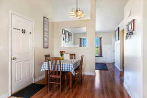Dining space featuring dark wood finished floors and a chandelier