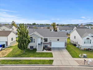 View of front of house with roof with shingles, concrete driveway, a residential view, a front lawn, and a garage