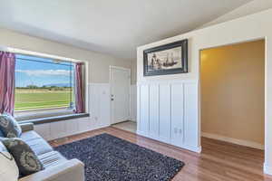 Living area featuring light wood finished floors, wainscoting, and a decorative wall