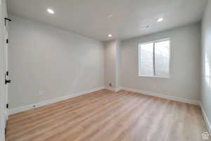 Empty room featuring light wood-style floors and recessed lighting
