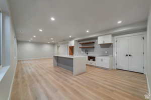 Kitchen with open shelves, decorative backsplash, white cabinets, light wood finished floors, and recessed lighting