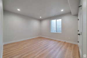 Empty room with light wood-type flooring and recessed lighting