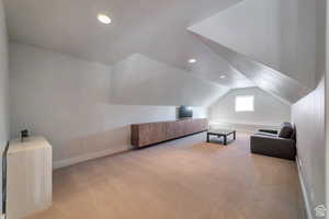 Additional living space featuring light colored carpet, recessed lighting, and lofted ceiling
