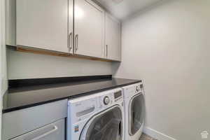 Laundry room featuring cabinet space and washer and clothes dryer
