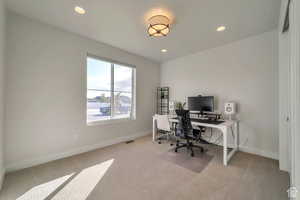 Office area with light colored carpet and recessed lighting