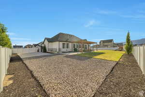 Back of property with a fenced backyard, a patio, and stucco siding