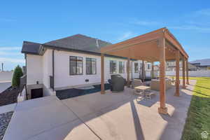 Rear view of property featuring outdoor lounge area, roof with shingles, a patio, and stucco siding