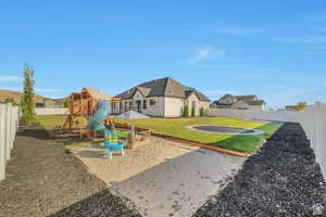 View of play area featuring a fenced backyard, a patio, and a residential view