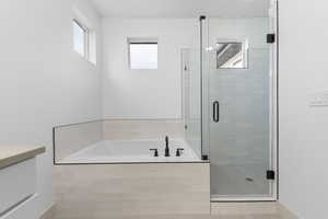 Bathroom with a bath, a stall shower, and vanity