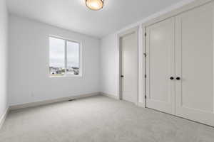 Unfurnished bedroom with carpet floors and two closets