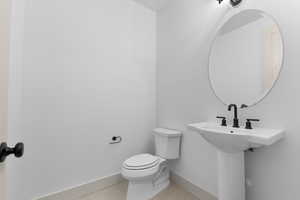 Bathroom with light tile patterned flooring and baseboards